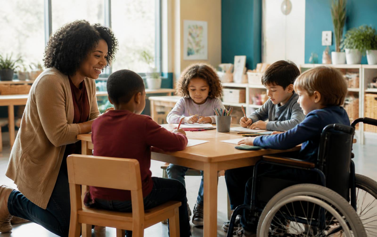 Enseignante accompagnant des enfants, dont un enfant en fauteuil roulant, autour d'une table dans une classe lumineuse